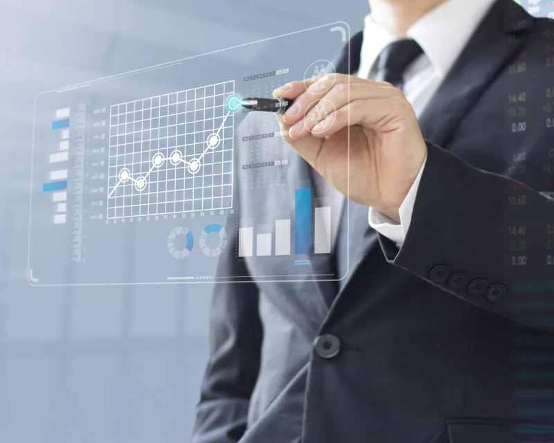 A tax expert providing tax compliance services by analyzing financial data on a modern, transparent screen.