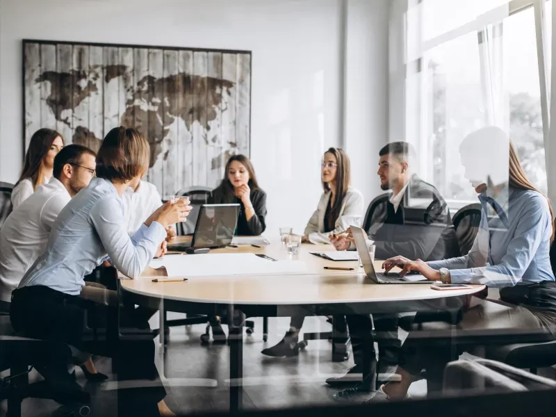 A diverse international team in a modern office, representing Greenfields' corporate services for Multi-National Corporations.