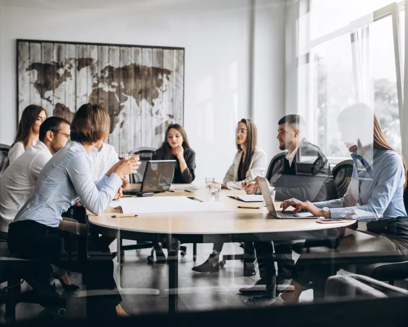 A diverse international team in a modern office, representing Greenfields' corporate services for Multi-National Corporations.