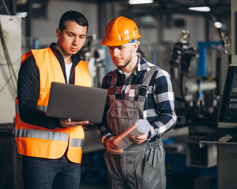 Two professionals on-site reviewing a project, representing Greenfields' corporate services for the Real Assets sector.