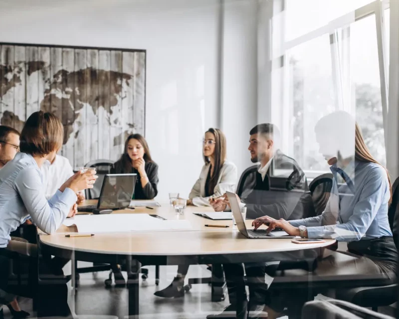 A diverse international team in a modern office, representing Greenfields' corporate services for Multi-National Corporations.