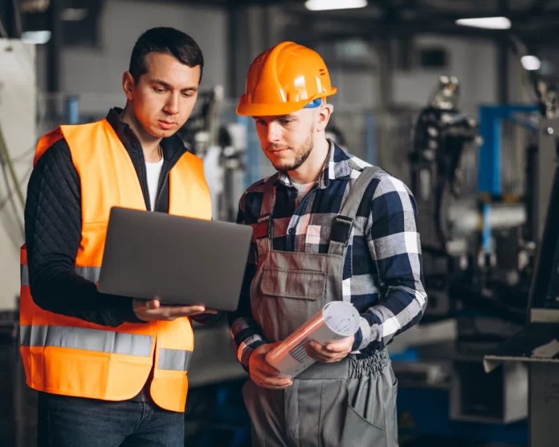 Two professionals on-site reviewing a project, representing Greenfields' corporate services for real assets sector.